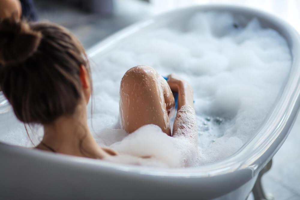 Woman taking a cold bubble bath