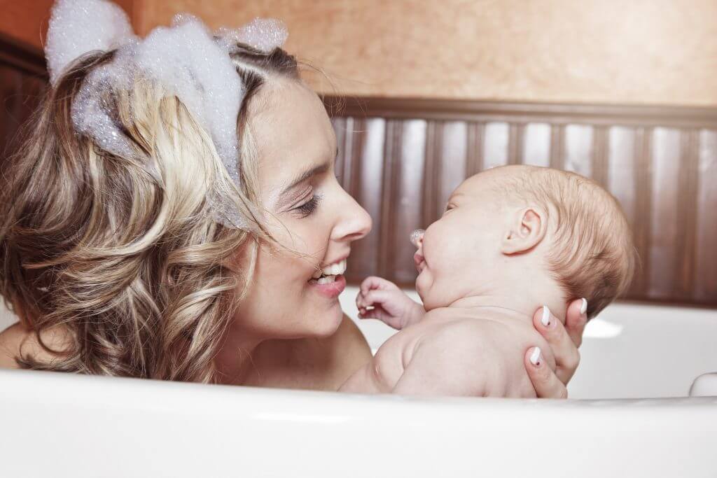 Mom taking a bubble bath with her baby